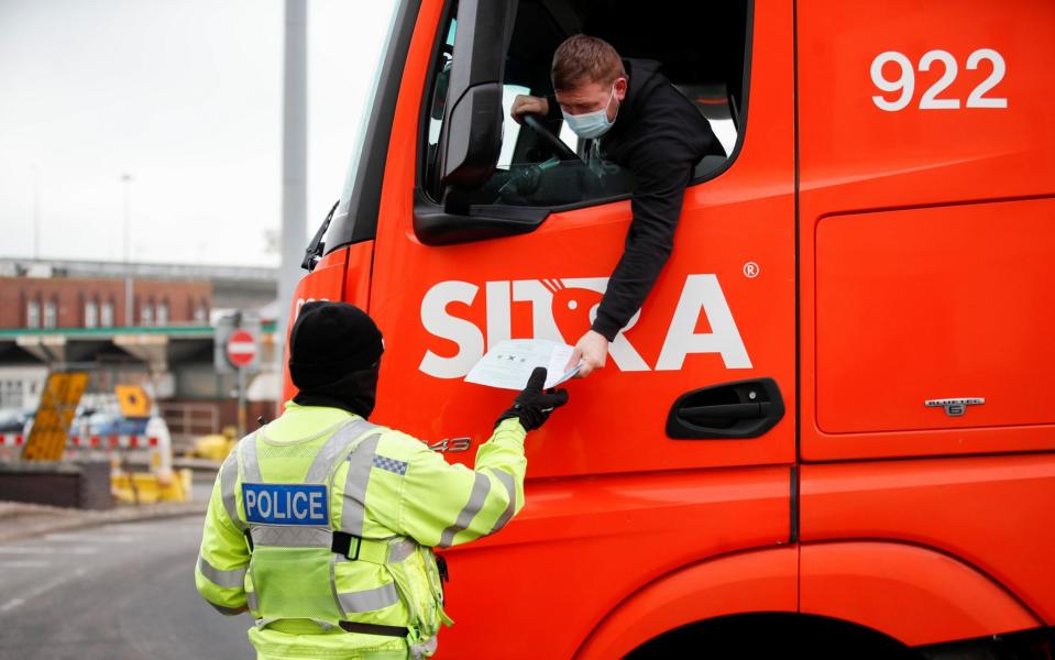 A police officer checks documents of a lorry driver as he enters the Port of Dover - Peter Cziborra/Reuters