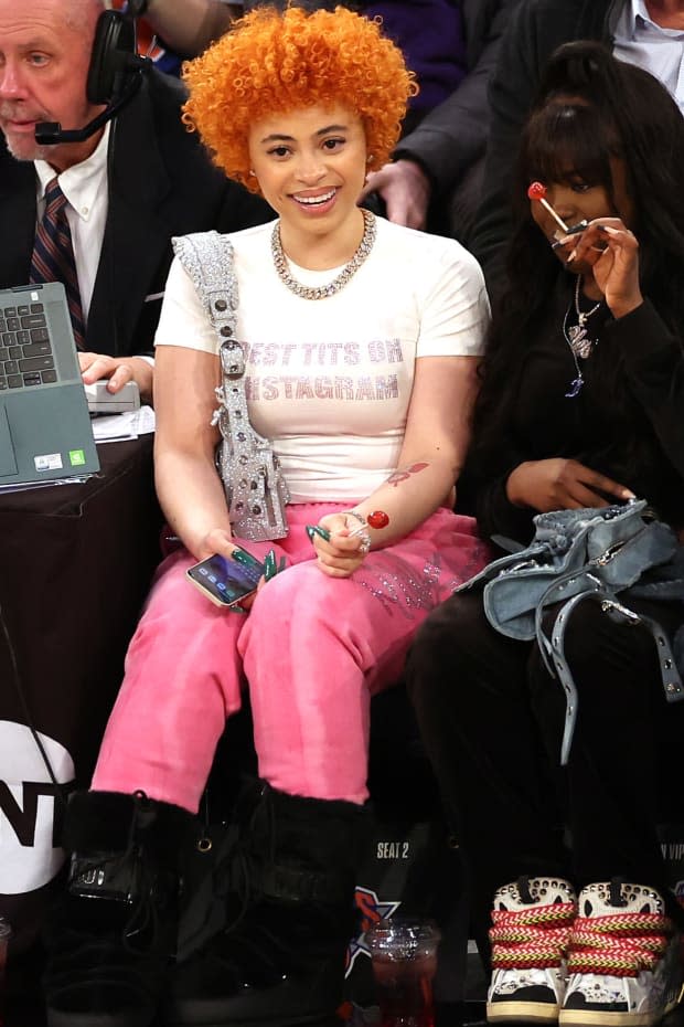 Ice Spice sitting stylish and courtside with Moon Boots, a glitzy chain, popping curls, emerald acrylics and a Blow Pop.<p>Photo: Sarah Stier/Getty Images</p>