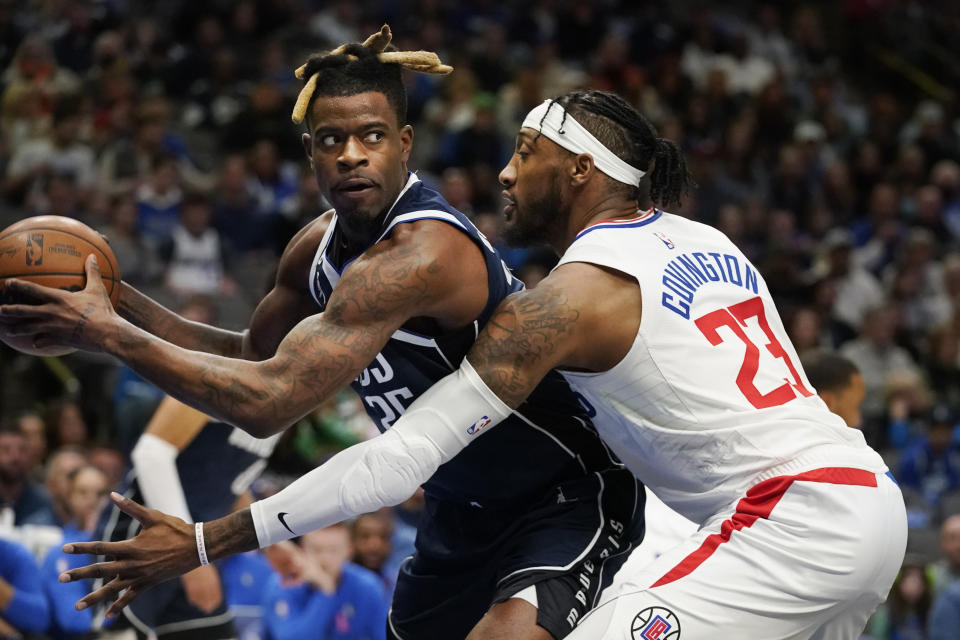 Dallas Mavericks forward Reggie Bullock keeps the ball from Los Angeles Clippers forward Robert Covington (23) during the first quarter of an NBA basketball game in Dallas, Sunday, Jan. 22, 2023. (AP Photo/LM Otero)