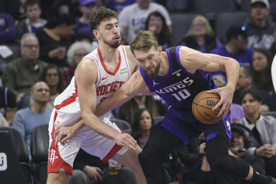 Houston Rockets center Alperen Sengun, left, guards Sacramento Kings forward Domantas Sabonis (10) during the first half of an NBA basketball game in Sacramento, Calif., Sunday, March 10, 2024. (AP Photo/Randall Benton)