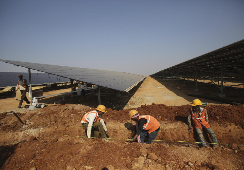 FILE - Laborers work at the Pavagada Solar Park north of Bangalore, India, March 1, 2018. Renewable projects have grown steadily in India for years, but a mix of policy decisions, politics and supply chain issues have slowed progress on solar projects in 2023. (AP Photo/Aijaz Rahi, File)