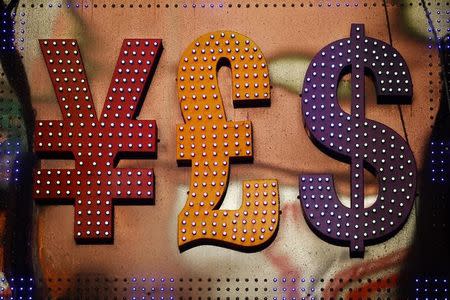 The dollar sign (R) is seen alongside the signs for other currencies above a currency exchange shop in Mongkok shopping district in Hong Kong October 30, 2014. REUTERS/Damir Sagolj