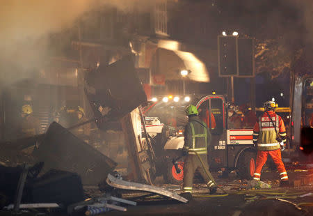 Members of the emergency services move debris at the site of an explosion which destroyed a convenience store and a home in Leicester, Britain, February 25, 2018. REUTERS/Darren Staples