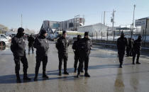 Police officers attend as members of rescue services work at the scene of a train accident, rear, in Ankara, Turkey, Thursday, Dec. 13, 2018. A high-speed train hit a railway engine and crashed into a pedestrian overpass at a station in the Turkish capital Ankara on Thursday, killing more than 5 people and injuring more than 40 others, officials and news reports said. (AP Photo/Burhan Ozbilici)