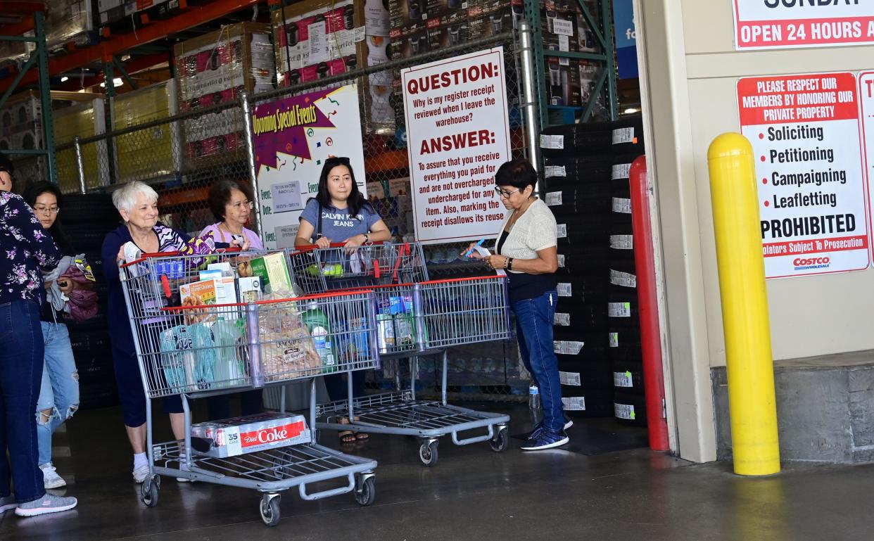 Shoppers have their receipts and carts checked by an employee as they exit from a Costco store in Alhambra, California, on August 19, 2019/