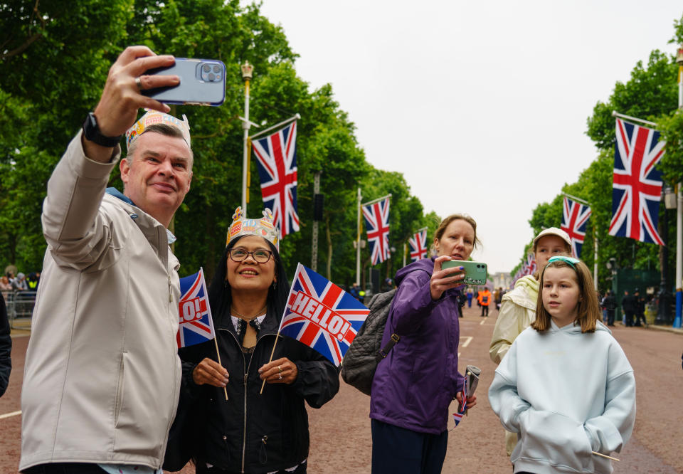 People pose for selfies on the Mall, ahead of the start of the Platinum Jubilee Pageant in front of Buckingham Palace, London, on day four of the Platinum Jubilee celebrations. Picture date: Sunday June 5, 2022.