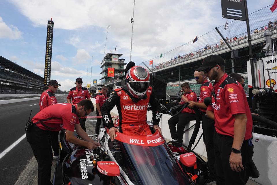 Will Power, center, of Australia, climbs into his car during a practice session for the Indianapolis 500 auto race at Indianapolis Motor Speedway, Friday, May 17, 2024, in Indianapolis. (AP Photo/Darron Cummings)