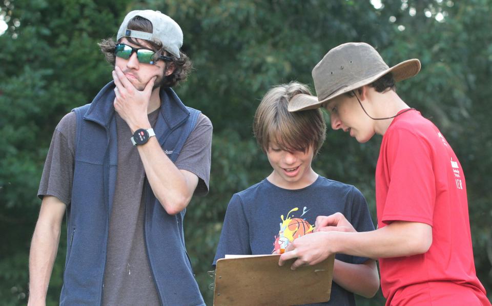 Hendersonville Boy Scouts with troop 628, from left, Torsten Salak, Demitri Becher and Henry Osiecki try to follow an orienteering course while working on their orienteering merit badge at Jackson Park on Aug 25.