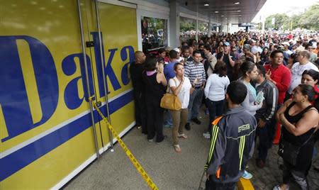 Shoppers crowd outside a Daka store as they wait to shop for electronic goods in Caracas November 9, 2013. Venezuelan President Nicolas Maduro ordered the military "occupation" of a chain of electronic goods stores in a crackdown on what the socialist government views as price-gouging hobbling the country's economy. REUTERS/Carlos Garcia Rawlins