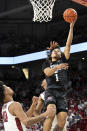 Texas A&M guard Marcus Williams (1) drives past Arkansas defenders Jaylin Williams (10) and Au'Diese Toney, rear, to score during the first overtime of an NCAA college basketball game Saturday, Jan. 22, 2022, in Fayetteville, Ark. (AP Photo/Michael Woods)