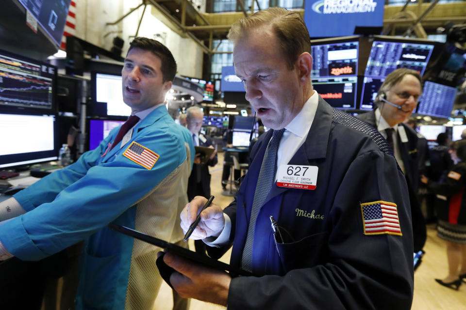 Specialist Thomas McArdle, left, and trader Michael Smyth, center, work on the floor of the New York Stock Exchange, Wednesday, Oct. 30, 2019. Stocks are slipping in early trading on Wall Street as traders hold back ahead of an interest rate announcement from the Federal Reserve. (AP Photo/Richard Drew)