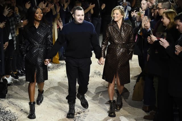 British designer Kim Jones (C) holds hands with British models Naomi Campbell (L) and Kate Moss (R)