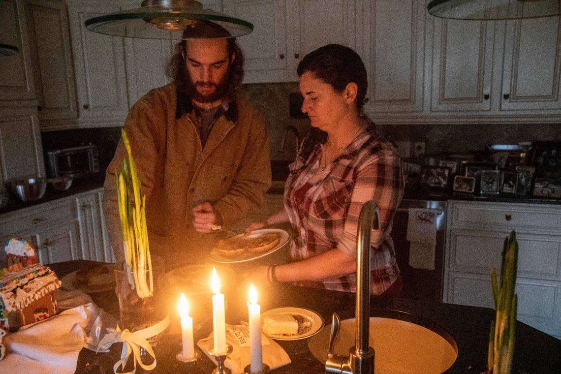 Sarah Baker and Scott Patterson make breakfast by candlelight Wednesday morning, Dec. 7, 2022 at Fox Lake Farm in Southern Pines. Two deliberate attacks on electrical substations in Moore County Saturday evening caused days-long power outages for tens of thousands of customers.