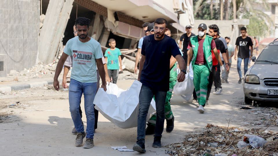 Palestinians recover bodies found under the rubble in Al-Sina'a Street, on July 12, following the withdrawal of Israeli forces in central and northern Gaza. - Omar Al-Qattaa/AFP/Getty Images