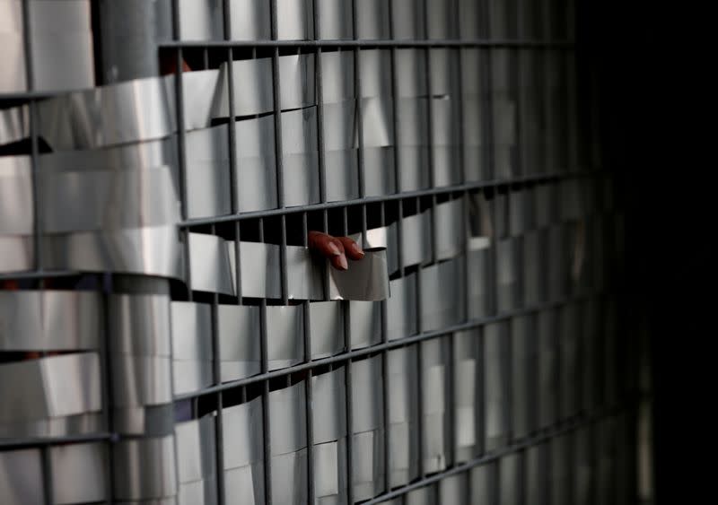 FILE PHOTO: A worker speaks through a fence with a friend to help with remittance at Punggol S-11 workers' dormitory in Singapore