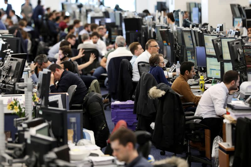 FILE PHOTO: Traders work on the trading floor of Barclays Bank at Canary Wharf in London