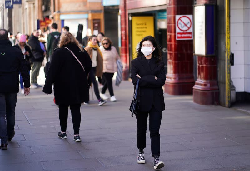 A woman wears a protective face mask in central London