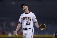 Arizona Diamondbacks starting pitcher Merrill Kelly smiles as he reenacts his closed eyes catch of a line drive hit by San Francisco Giants' Brandon Belt during the fifth inning of a baseball game, Thursday, Aug. 5, 2021, in Phoenix. (AP Photo/Ross D. Franklin)