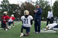 Gallaudet football head coach Chuck Goldstein, center right, talks with running back Joshua Kelley, left, using American Sign Language during football practice at Hotchkiss Field, Tuesday, Oct. 10, 2023, in Washington. (AP Photo/Stephanie Scarbrough)