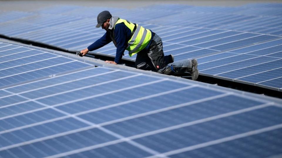 Un técnico repara unos páneles solares en Alemania.