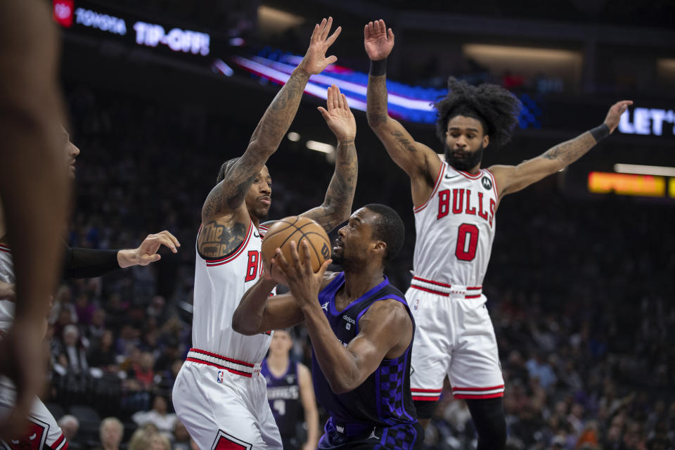 Chicago Bulls forward DeMar DeRozan and guard Coby White (0) defend Sacramento Kings forward Harrison Barnes in the first quarter of an NBA basketball game in Sacramento, Calif., Monday, March 4, 2024. (AP Photo/José Luis Villegas)