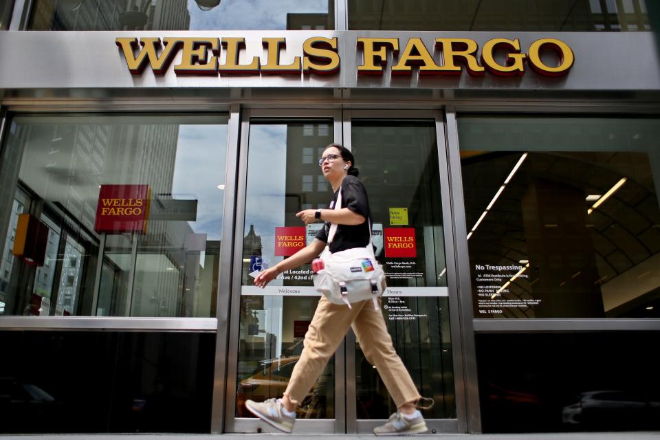 A woman walking outside a Wells Fargo building.