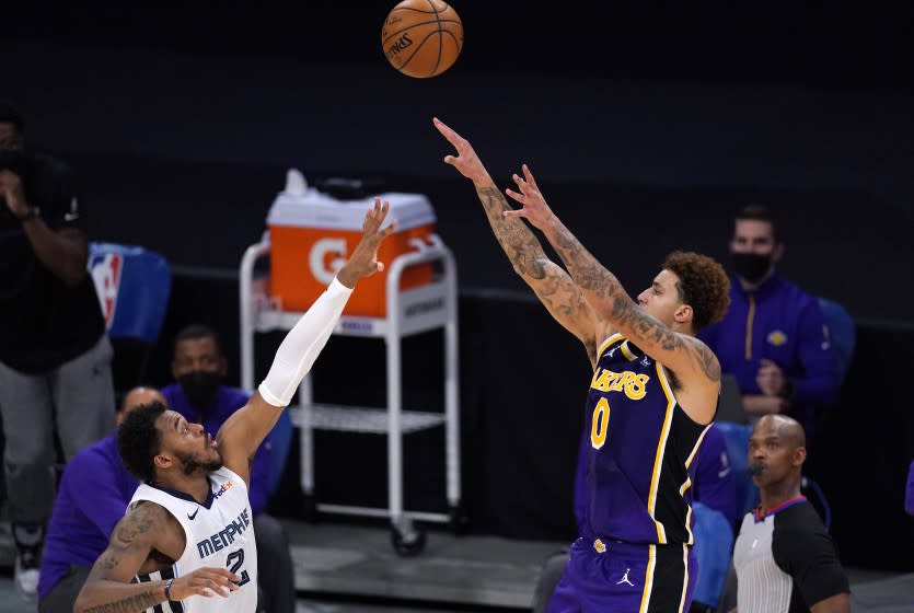 Los Angeles Lakers forward Kyle Kuzma, right, shoots as Memphis Grizzlies center Xavier Tillman.