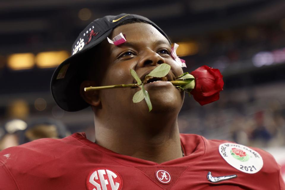 Alabama offensive lineman Javion Cohen holds a rose between his teeth after their 31-14 win against Notre Dame in the Rose Bowl NCAA college football game in Arlington, Texas, Friday, Jan. 1, 2021. (AP Photo/Michael Ainsworth)