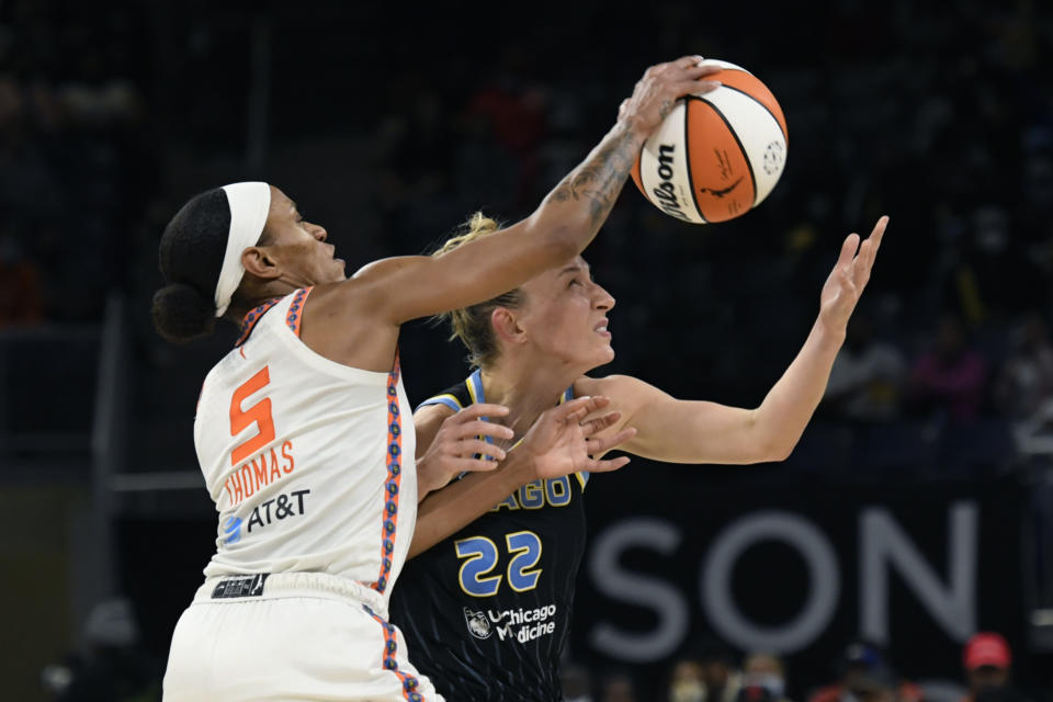 Chicago Sky's Courtney Vandersloot (22) and Connecticut Sun's Jasmine Thomas (5) reach for the ball during the first half of Game 4 of a WNBA basketball playoff series Wednesday, Oct. 6, 2021, in Chicago. (AP Photo/Paul Beaty)