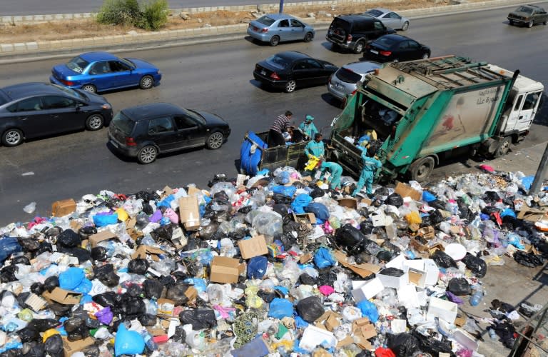 Garbage collectors remove waste from a street in Beirut's eastern suburb of Dora to a temporary location outside of the Lebanese capital on August 31, 2015