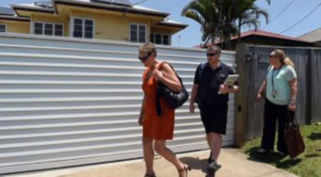 Officials from the Department of Education and Training leave the house after unsuccessfully trying to talk to people inside. Source: AAP.