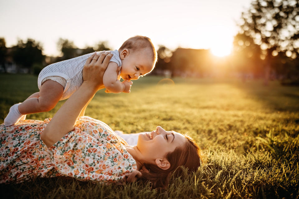 Mother and baby laying down in meadow