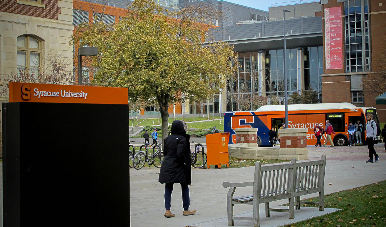 FILE — Students walk the campus on Syracuse University, Nov. 21, 2019, in New York. Syracuse announced that all eligible students and employees must get COVID-19 booster shots before the spring term. Students will also face virus tests when they return, and officials are weighing whether to extend a mask mandate. (AP Photo/Carolyn Thompson, File)