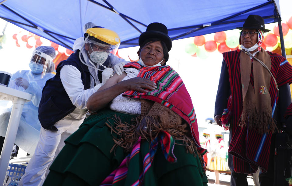 La residente boliviana Lucia Ticona recibe una inyección de la vacuna Sinopharm contra COVID-19 durante la vacunación de personas mayores de 50 años, en la frontera que conecta Desaguadero, Bolivia, con Desaguadero, Perú, el viernes 21 de mayo de 2021. (AP Foto/Juan Karita)