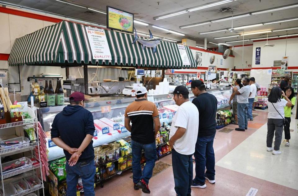 Customers shop for fresh seafood at Central Fish Company in Chinatown, photographed Saturday, Oct. 21, 2023 in downtown Fresno.