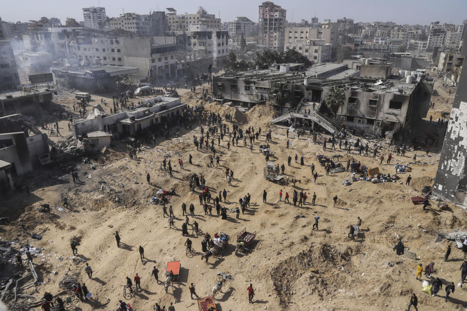 Palestinians walk through the destruction left by the Israeli air and ground offensive on the Gaza Strip near Shifa Hospital in Gaza City, Monday, April 1, 2024. (AP Photo/Mohammed Hajjar)