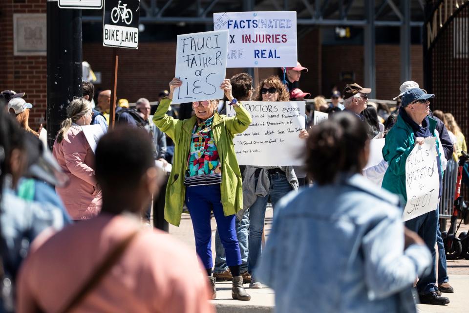 People protest Anthony Fauci outside of the Michigan Stadium in Ann Arbor  during the Comeback Commencement for the Class of 2020 and 2021 on Saturday, May 7, 2022.