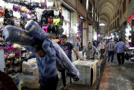 In this June 23, 2019, photo, people carry on about their business in the main bazaar in Tehran, Iran. As the U.S. piles sanction after sanction on Iran, it’s the average person who feels it the most. (AP Photo/Ebrahim Noroozi)