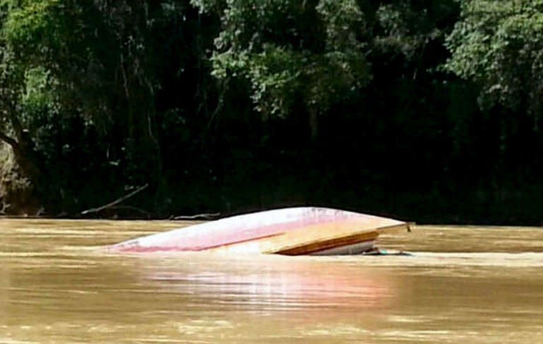 An overturned boat floats in the Rajang River near Belaga, in Malaysia's Sarawak state on the island of Borneo, on May 28, 2013. One person is confirmed dead and about a dozen are still missing two days after the overloaded ferry capsized in rough rapids on the remote Borneo river, Malaysian police say