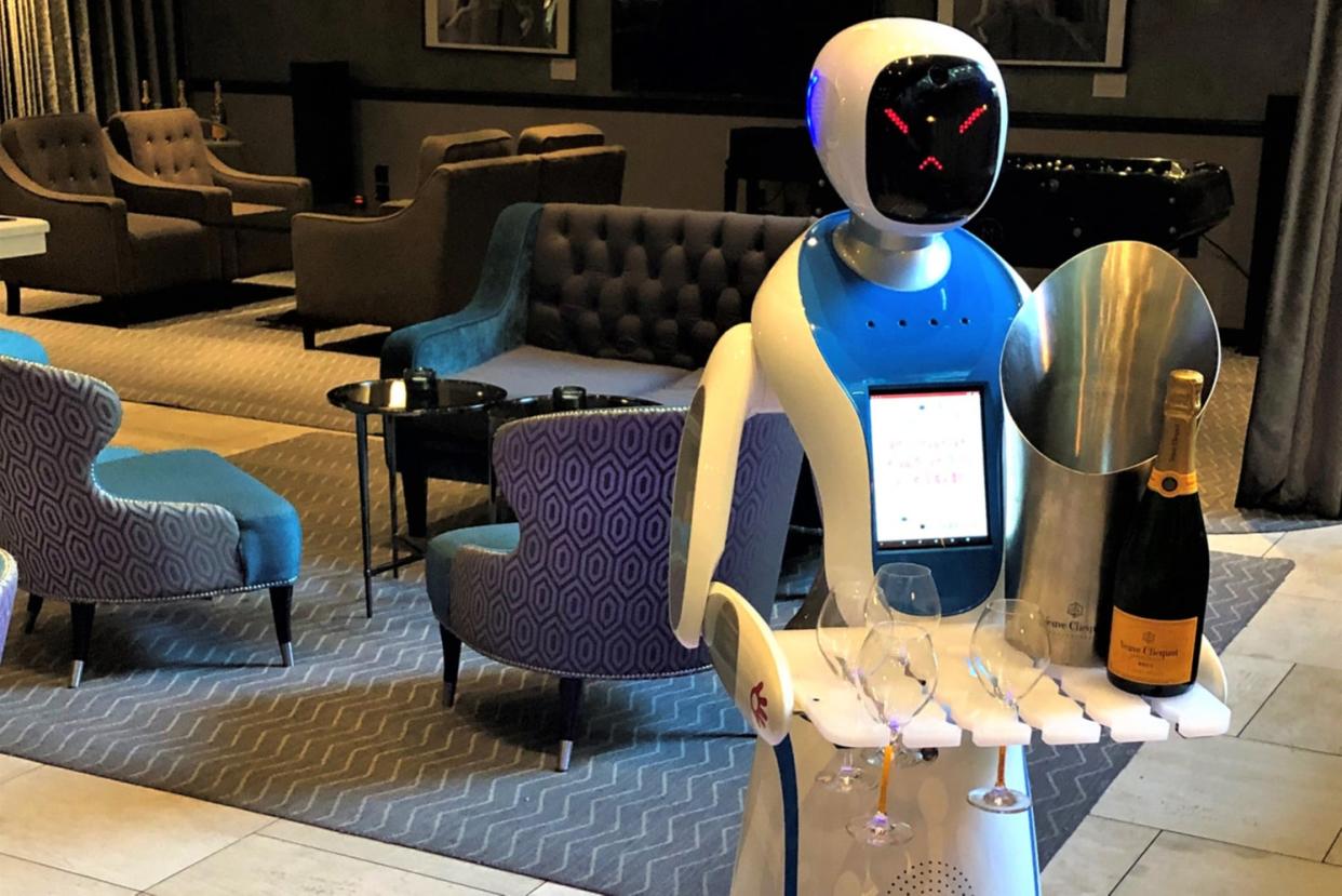 <p>Bots bearing gifts: the machine may have an unhappy face, but it does at least deliver bottle of bubbly </p> (M Restaurants)