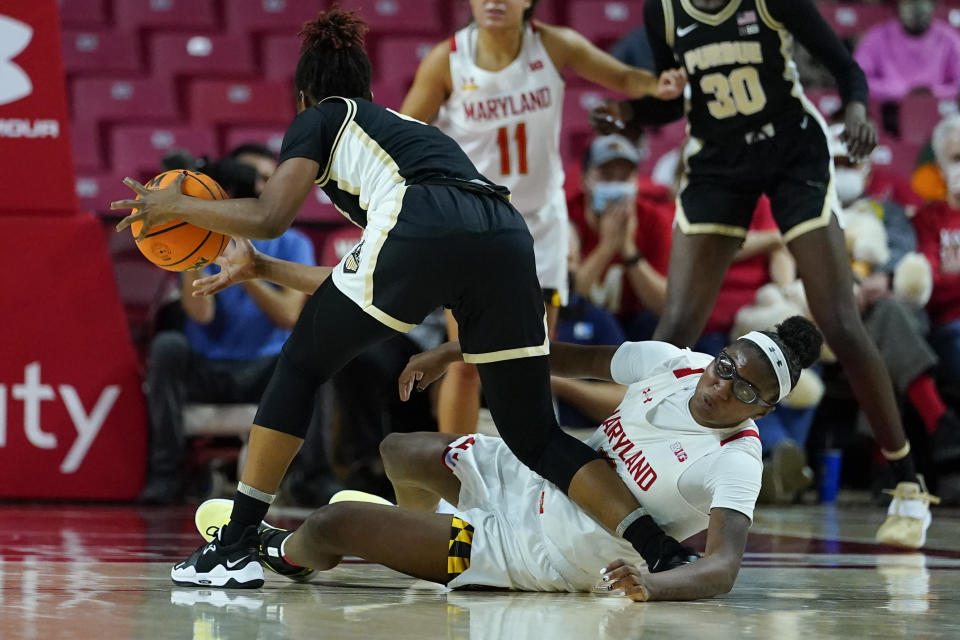 Maryland guard Shyanne Sellers, bottom, crashes onto Purdue guard Rokia Doumbia, left, while challenging for the ball during the first half of an NCAA college basketball game, Wednesday, Dec. 8, 2021, in College Park, Md. (AP Photo/Julio Cortez)