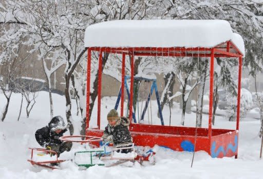 Children play on a snow-covered merry-go-round in Yerevan, Armenia