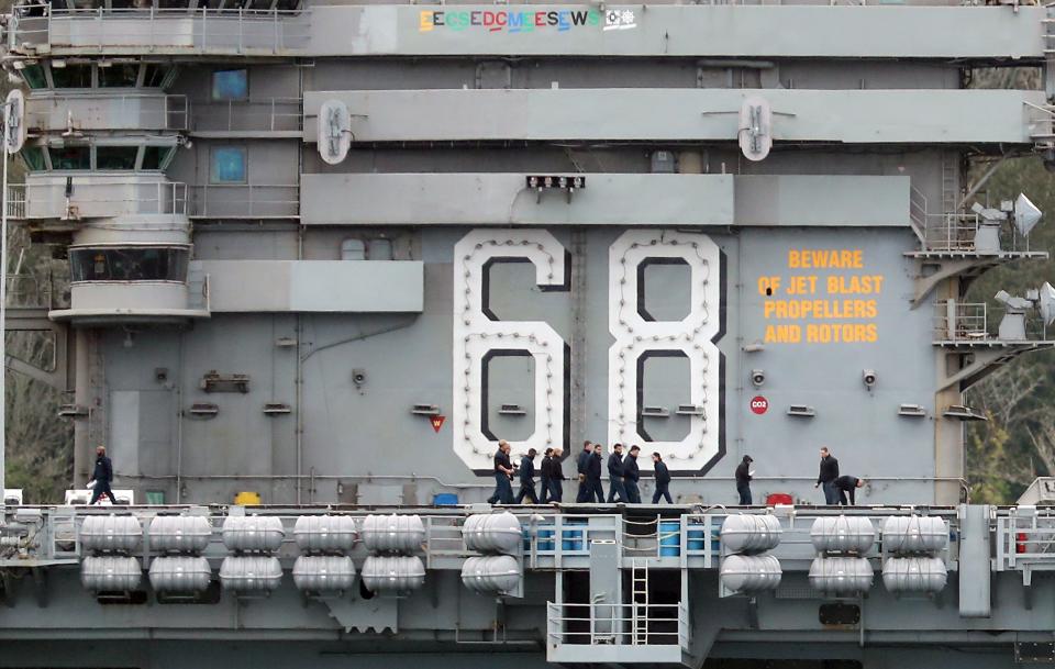 USS Nimitz sailors walk past the 68 as the aircraft carrier passes Bachmann Park in Bremerton on Monday.