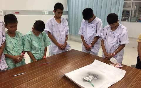 Images of the children in their hospital gowns with their heads bowed low were released on Sunday  - Credit:  AFP