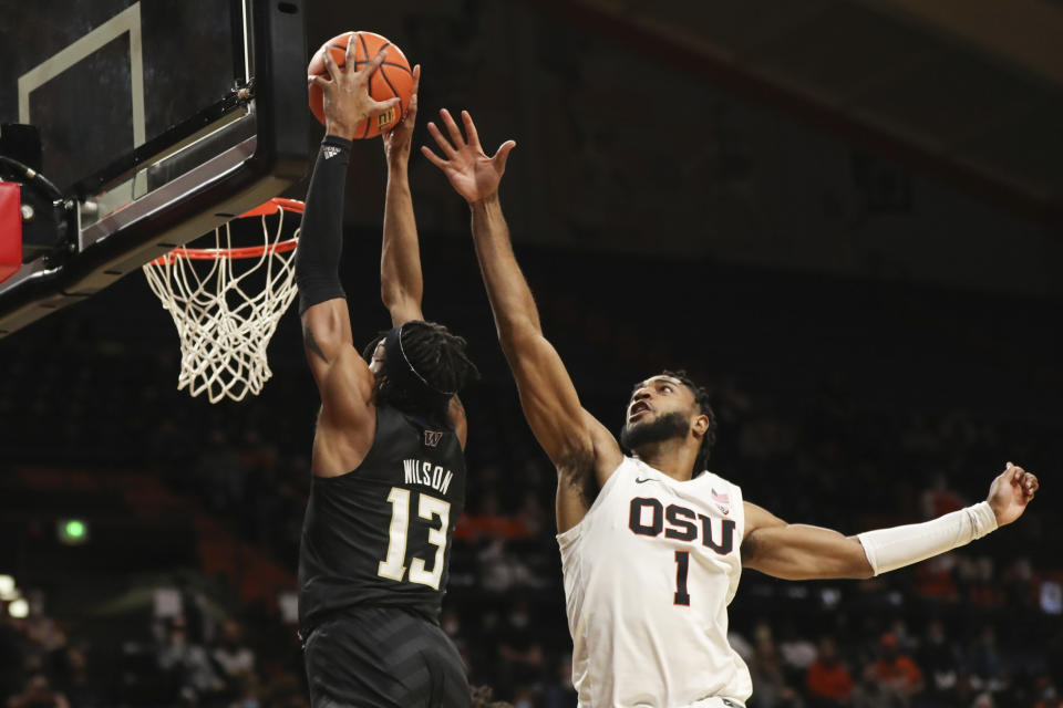 Oregon State's Maurice Calloo (1) tries to block a shot by Washington's Langston Wilson (13) during the first half of an NCAA college basketball game Thursday, Jan. 20, 2022, in Corvallis, Ore. (AP Photo/Amanda Loman)