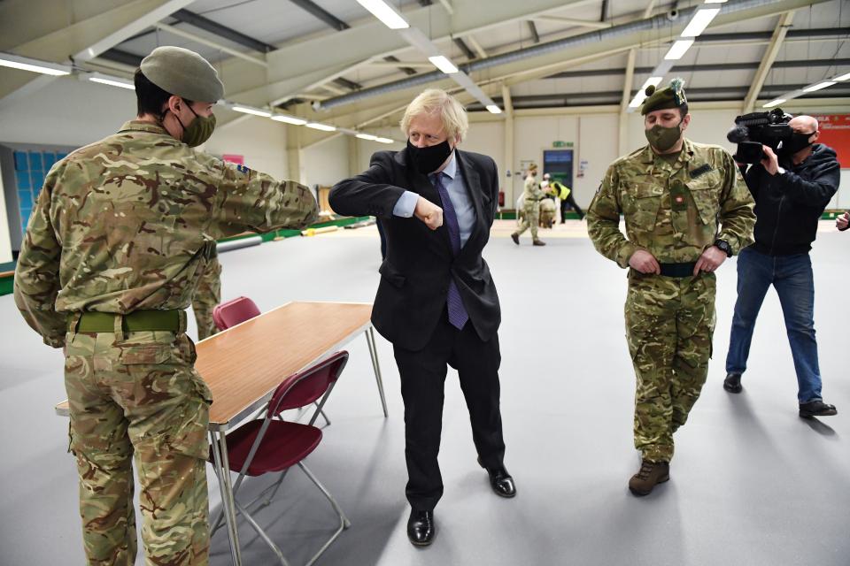 Britain's Prime Minister Boris Johnson meets troops as they set up a vaccination centre in the Castlemilk district in Glasgow, Scotland on January 28, 2021, during a COVID-19 related visit to the country. - Prime Minister Boris Johnson headed to Scotland on Thursday to praise the United Kingdom's collective response to coronavirus, in a bid to counter record support for independence. (Photo by Jeff J Mitchell / POOL / AFP) (Photo by JEFF J MITCHELL/POOL/AFP via Getty Images)