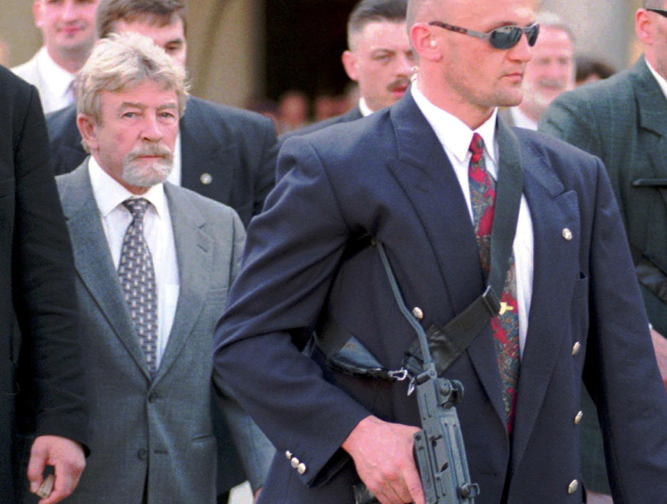 In this file photo of April 30, 1998, surrounded by bodyguards, Poland’s Cold War spy, Ryszard Kuklinski, left, visits Krakow, southern Poland. From behind the Iron Curtain, Kuklinski passed some 35,000 pages of Warsaw Pact secrets to the CIA, including the communist government's plan to impose martial law in 1981 and launch a brutal crackdown on the pro-democracy Solidarity movement. He was spirited out of Poland with his wife and two sons shortly before the Dec. 13, 1981 military crackdown, and the family lived in hiding in the U.S. Poland’s military court sentenced him to death for treason and desertion. The charges were lifted in 1998 and Kuklinski came on a visit.(AP Photo/Czarek Sokolowski)