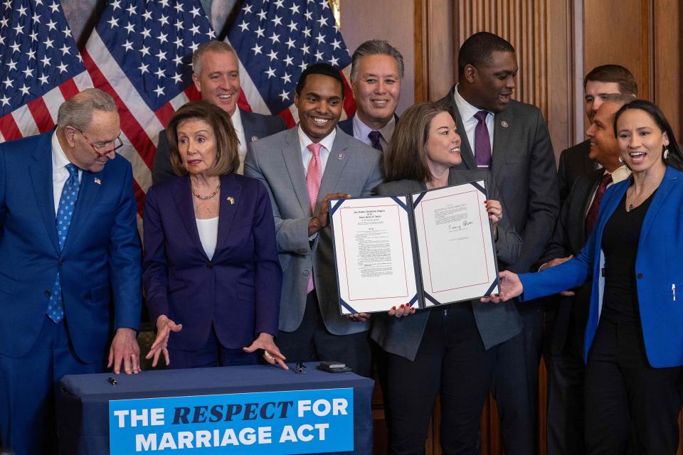 House Speaker Nancy Pelosi, D-Calif., speaks with Senate Majority Leader Chuck Schumer, D-N.Y, as Senate and House members participate in a bill enrollment ceremony for the Respect For Marriage Act on Thursday.