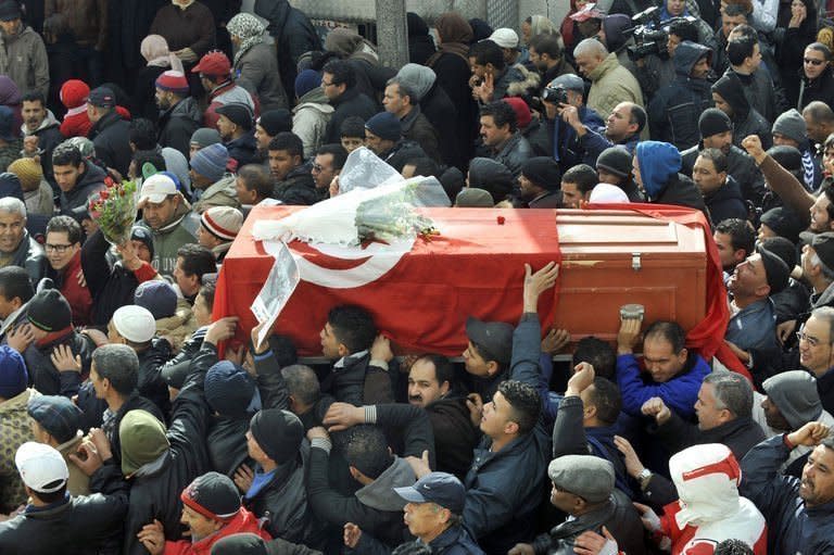 Mourners carry the coffin of late opposition leader Chokri Belaid during his funeral procession to the El-Jellaz cemetery in the Djebel Jelloud suburb of Tunis, on February 8, 2013. Tunisian police have fired tear gas and clashed with protesters as tens of thousands joined the funeral of opposition leader Chokri Belaid whose murder plunged the country into new post-revolt turmoil