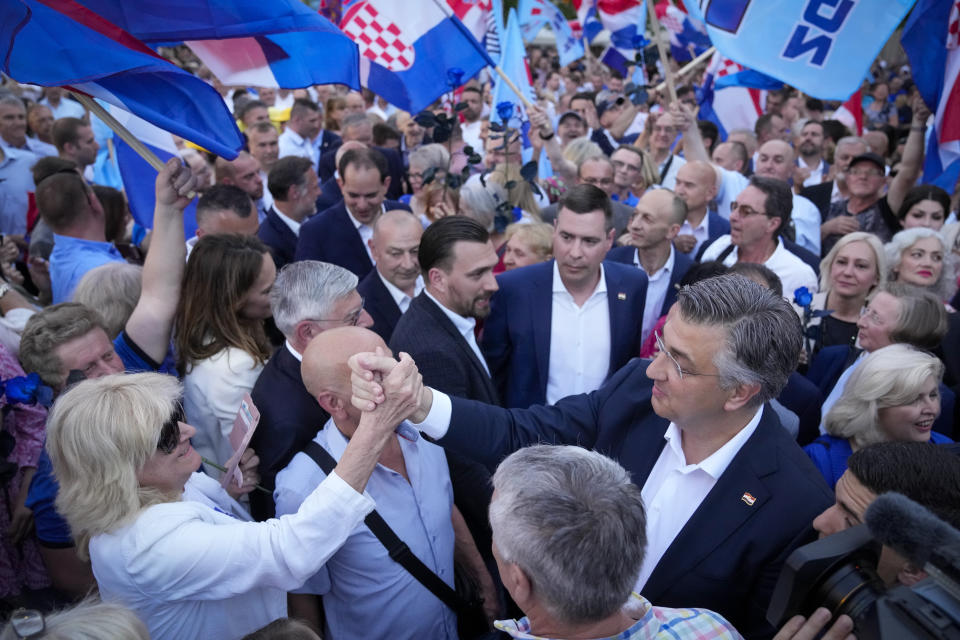 Prime Minister incumbent Andrej Plenkovic, right, greets supporters during a rally in Zagreb, Croatia, Sunday, April 14, 2024. Croatia this week holds an early parliamentary election following a campaign that was marked by heated exchanges between the country's two top officials, creating a political crisis in the Balkan country, a European Union and NATO member state. (AP Photo/Darko Bandic)
